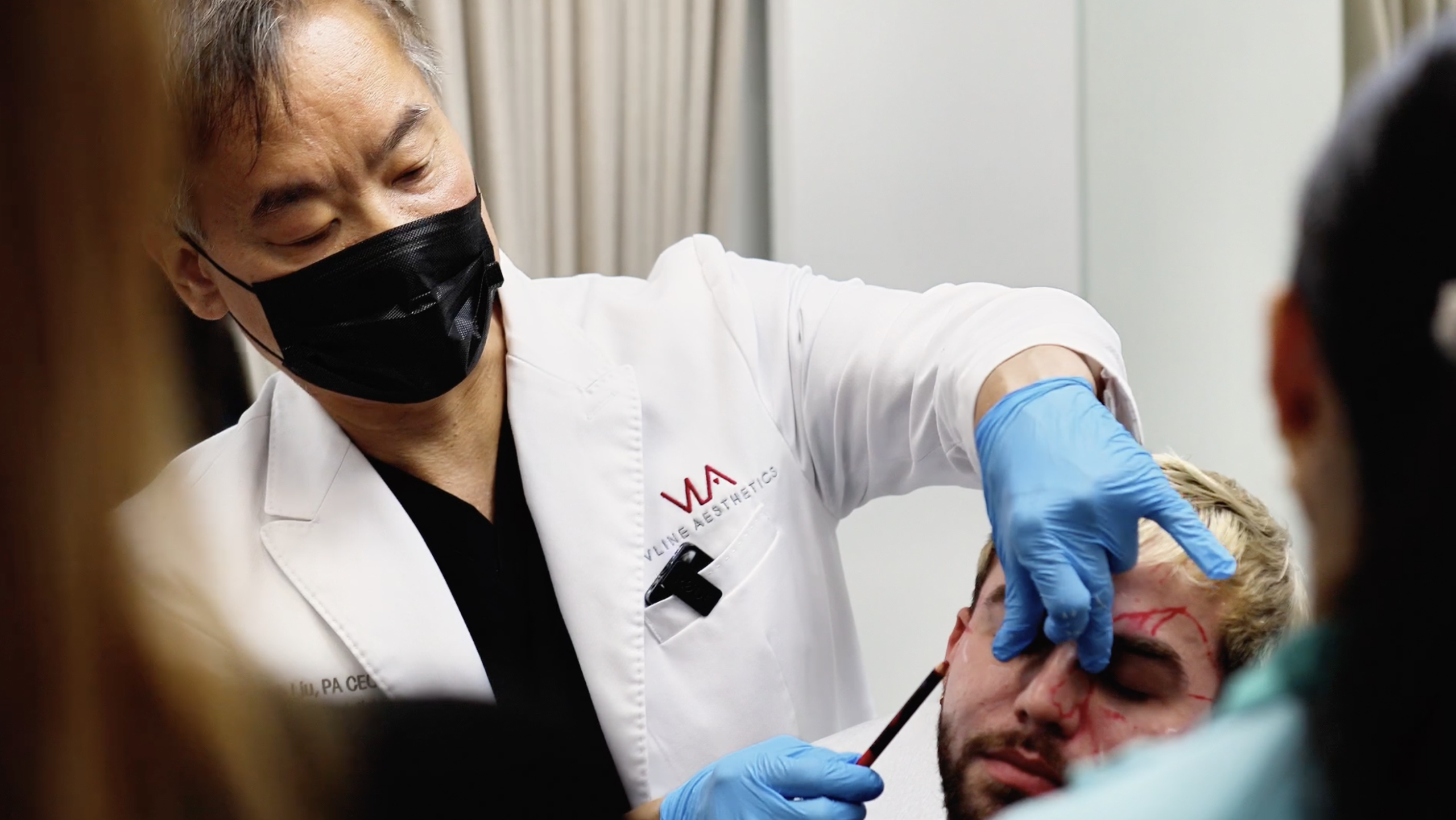 Practitioner marking facial anatomy during hands-on training